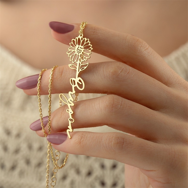 Birth Flower Name Necklace close-up on models manicured hand. 