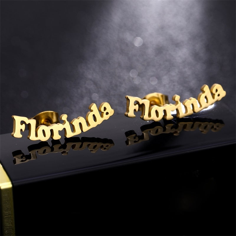 Nameplate Stud Earrings on reflective background