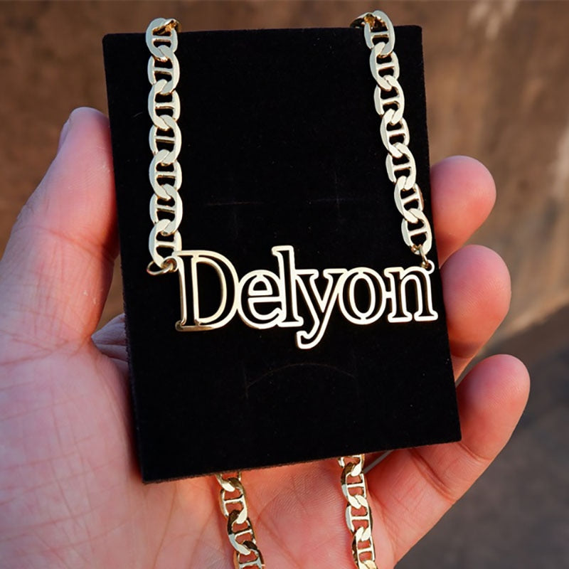 Metro Outline Name Necklace on black background in model's hand