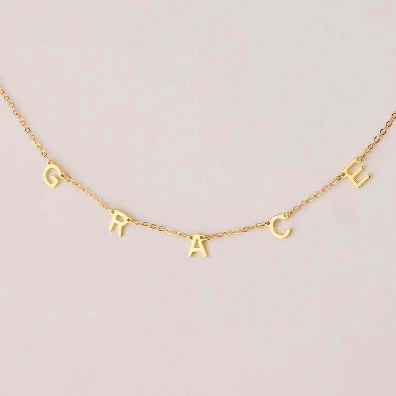 Charm Letter Name Necklace in gold close-up on white background